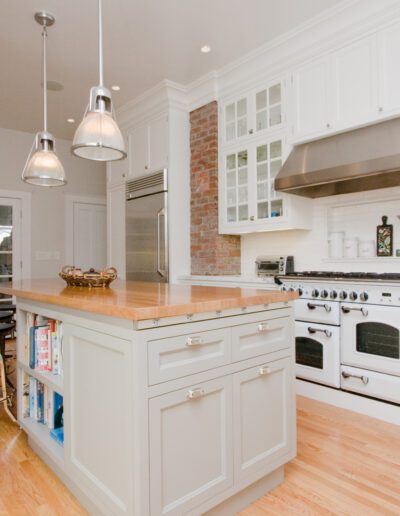 Modern kitchen interior with white cabinetry, stainless steel appliances, and a central island.